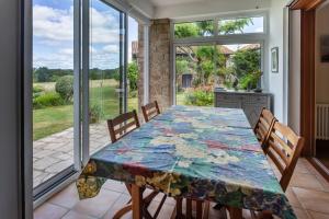 a dining room with a table and chairs and a window at Chambres hôtes Le Champ Des Oiseaux in Rochechouart
