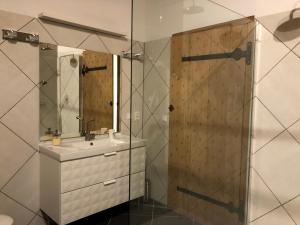 a bathroom with a sink and a shower with a mirror at La Maison Forte in Courtenay