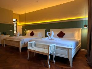 two beds with swans on them in a bedroom at The Chambers Georgetown in George Town