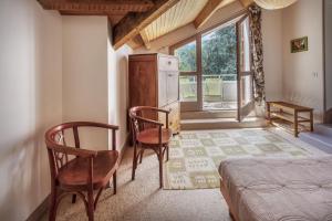 a bedroom with two chairs and a bed and a window at Chambres hôtes Le Champ Des Oiseaux in Rochechouart