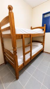 two wooden bunk beds in a room at Armorial Hostel in João Pessoa
