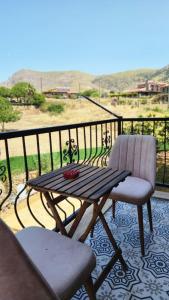 a wooden table and a chair on a balcony at Bergüzar Hanım Konukevi in Gokceada Town