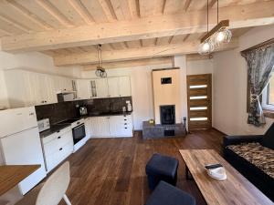 a large kitchen and living room with a couch and a table at Chata do Zlatneho in Terchová