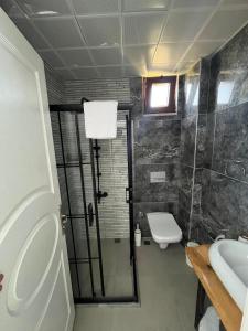 a bathroom with a shower and a toilet and a sink at Bergüzar Hanım Konukevi in Gokceada Town