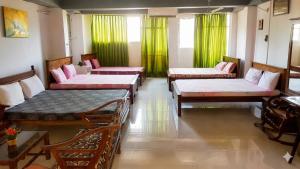 a room with four beds and green curtains at The Beehive in Bambalapitiya