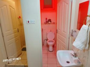 a bathroom with a pink toilet and a sink at Shikaz Homes 2 Bedroom Near Jkia Airport in Nairobi