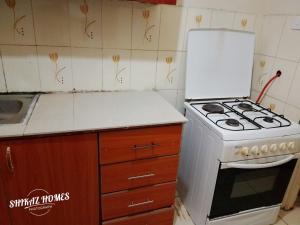 a kitchen with a white stove and a sink at Shikaz Homes 2 Bedroom Near Jkia Airport in Nairobi +16 photos