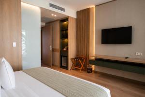 a hotel room with a bed and a flat screen tv at Arkk Rooms in Antalya