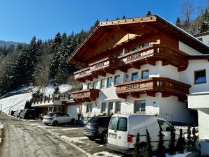 a large building with cars parked in front of it at Landhaus Rieder im Zillertal in Aschau