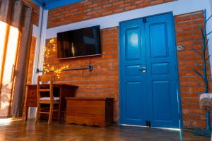 a blue door in a room with a brick wall at Espaço Aricá in Chapada dos Guimarães
