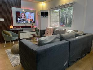 a living room with a large couch and a tv at Casa Gutierrez in Lingayen