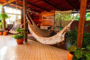 a hammock hanging in a room with plants at Espaço Aricá in Chapada dos Guimarães