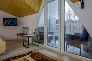 a room with sliding glass doors and a table and chairs at Алексік in Truskavets