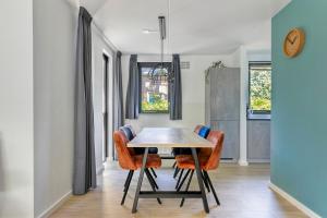a dining room with a table and orange chairs at 6 - Person Forest 183 Bungalow in Ewijk +39 photos