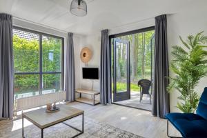a living room with a blue couch and a tv at 6 - Person Forest 183 Bungalow in Ewijk