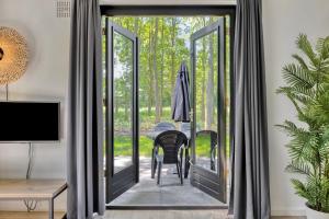 an open door to a dining room with a table and chairs at 6 - Person Forest 183 Bungalow in Ewijk