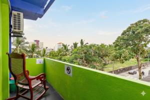 a chair on a balcony with a green wall at The Beehive in Bambalapitiya