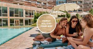 a group of people sitting next to a swimming pool at Falkensteiner Hotel & Spa Carinzia l 4 Star Superior in Tröpolach +40 photos