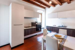 a kitchen with white cabinets and a table and chairs at Borghetto Lake House in Valeggio sul Mincio +36 photos