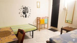 a room with a table and a bed and a table and chairs at The Beehive in Bambalapitiya