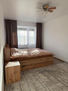 a bedroom with a bed and a ceiling fan at Панорама in Borysxaw