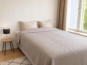 a bedroom with a bed with a table and a window at Kotkan Studio in Kotka