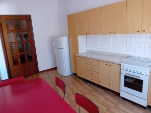 a kitchen with a table and a white stove and refrigerator at Guest House Soma Montecchio in Montecchio Emilia +2 photos