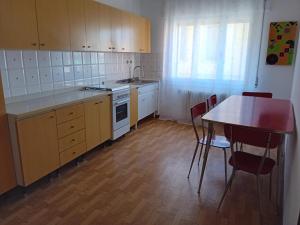 a kitchen with wooden cabinets and a table and chairs at Guest House Soma Montecchio in Montecchio Emilia