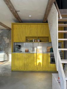 a kitchen with mustard yellow cabinets in a room at Modern seaside barn in Borrby