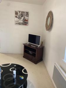 a living room with a tv and a table at Ferme des hospices in La Celle-sous-Gouzon
