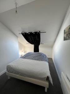 a bedroom with a bed with a black curtain at Ferme des hospices in La Celle-sous-Gouzon