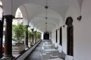 ベルガモにあるLa Casetta Apartmentの白いテーブルと椅子が並ぶ廊下