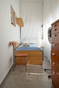 特拉維夫的住宿－Miraks Ge'ula，一间小卧室,配有一张床和一把椅子