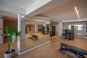 a gym with several treadmills and a large mirror at Oya Beach Resort in Hersonissos