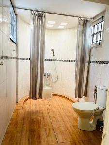 a bathroom with a toilet and a shower at Rainforest Munnar in Munnar +88 photos