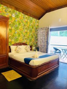 a bedroom with a bed in a room with a wall at Rainforest Munnar in Munnar