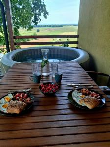 a wooden table with two plates of food on it at Počitniška hiša Car in Dobrovnik +8 photos