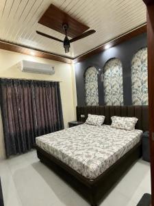 a bedroom with a bed and a ceiling fan at Samarpan in Gorakhpur