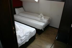 a small room with two beds with white sheets at Alexander 3327 in Bansko