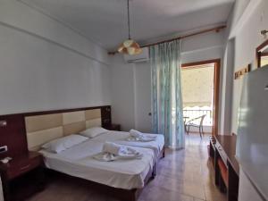 a bedroom with two beds and a large window at Μπαλκόνι Στο Γαλάζιο in Agios Georgios