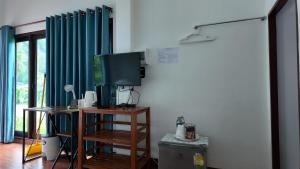 a living room with a tv and a table with a television at Sanfhan Resort-SHA Plus in Khao Chai Son +92 photos