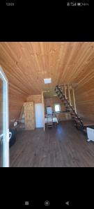 a large room with a wooden ceiling with stairs in it at Cottage Irko in Tvebishi