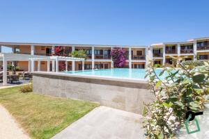 a large building with a swimming pool in front of it at Hotiday Punta Sardegna in Palau
