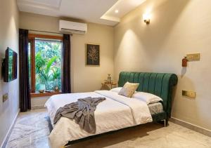 a bedroom with a green bed and a window at Giovanni House in Bhopal