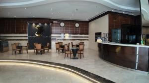 a restaurant with a bar and tables and chairs at أجنادين للشقق المخدومة in Riyadh