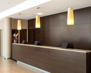 a reception desk in a hotel lobby with lights at PLAZA INN Hamburg Horner Rennbahn in Hamburg