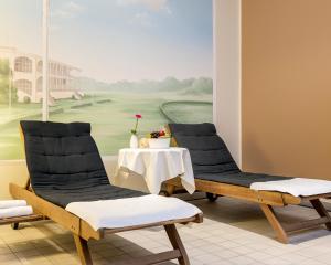 a room with two chairs and a table with a painting at PLAZA INN Hamburg Horner Rennbahn in Hamburg