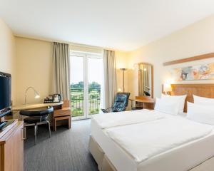 a hotel room with a bed and a desk at PLAZA INN Hamburg Horner Rennbahn in Hamburg