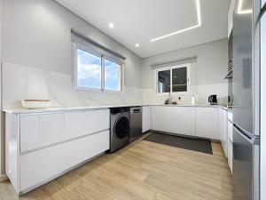 a white kitchen with a washer and dryer at Recanto do Sol by Atlantic Holiday in Caniçal