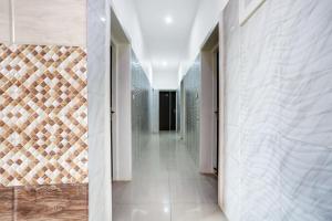 a corridor of a bathroom with white walls and tiles at Hotel O Jammu Near Ragunath Bazaar Formerly GoodWill in Jammu